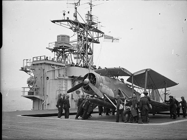 A Swordfish being lifted on the deck of an Attacker class carrier.